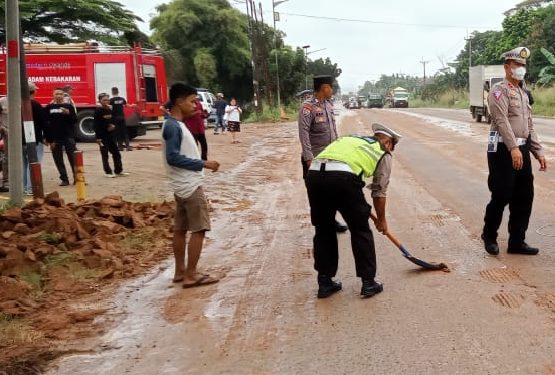 Personil Polsek Cikande Bersihkan Tanah Proyek Cut and Fill Berceceran di Jalanan